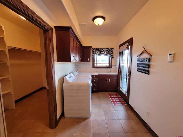 clothes washing area with sink, light tile patterned floors, cabinets, and independent washer and dryer