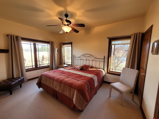 carpeted bedroom featuring ceiling fan and multiple windows