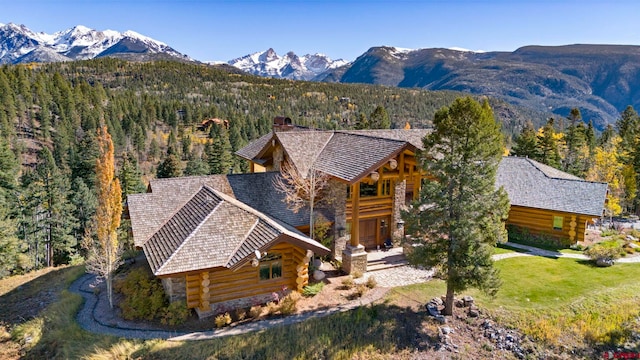 exterior space with a mountain view, a balcony, and a front lawn