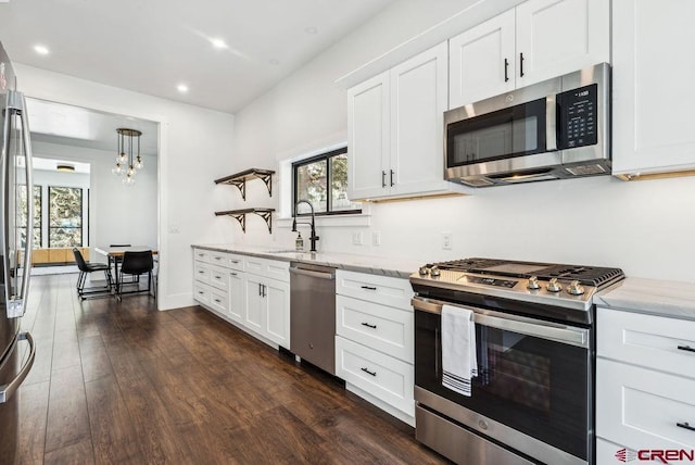 kitchen with light stone countertops, sink, stainless steel appliances, dark hardwood / wood-style floors, and white cabinets