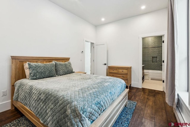 bedroom with ensuite bathroom and dark wood-type flooring