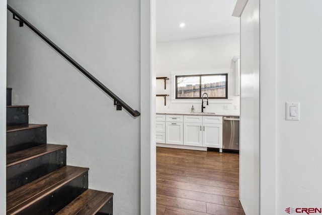 stairway with wood-type flooring and sink