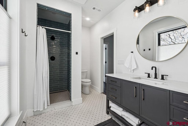 bathroom featuring toilet, a shower with curtain, vanity, and tile patterned floors