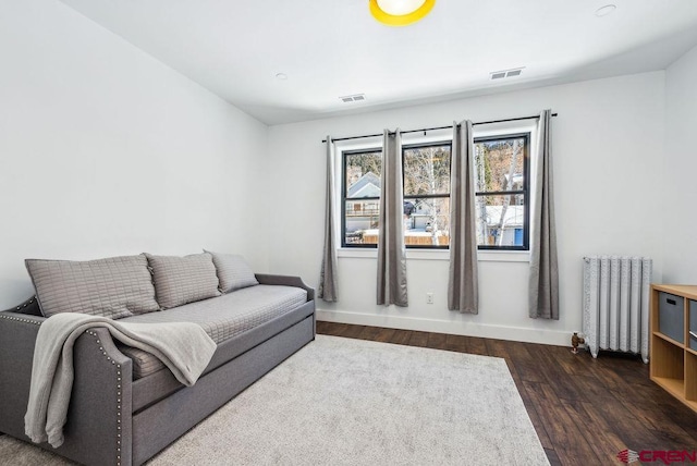 living room with radiator and dark wood-type flooring