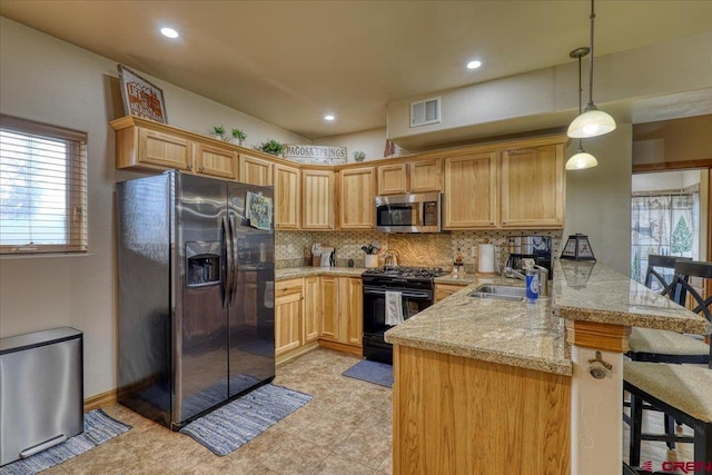 kitchen with sink, a kitchen breakfast bar, kitchen peninsula, decorative light fixtures, and appliances with stainless steel finishes