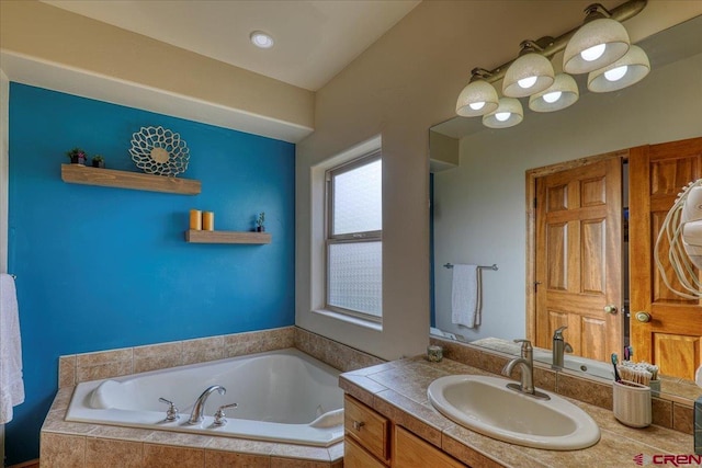 bathroom with tiled bath and vanity