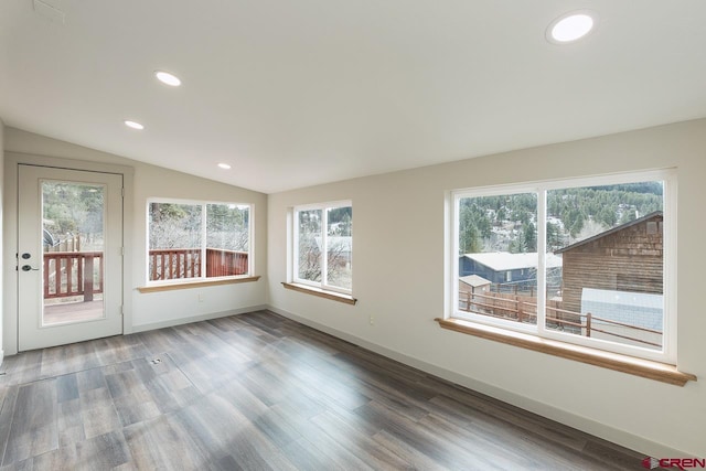 unfurnished room with wood-type flooring and lofted ceiling