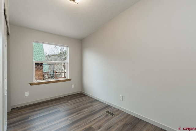 unfurnished room with dark hardwood / wood-style floors and lofted ceiling