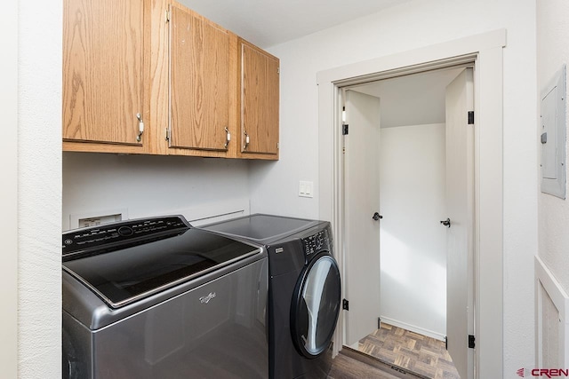 washroom with independent washer and dryer, electric panel, cabinets, and parquet flooring