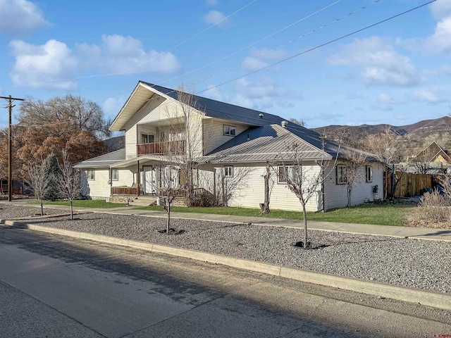 view of front of home featuring a mountain view, a balcony, and a porch