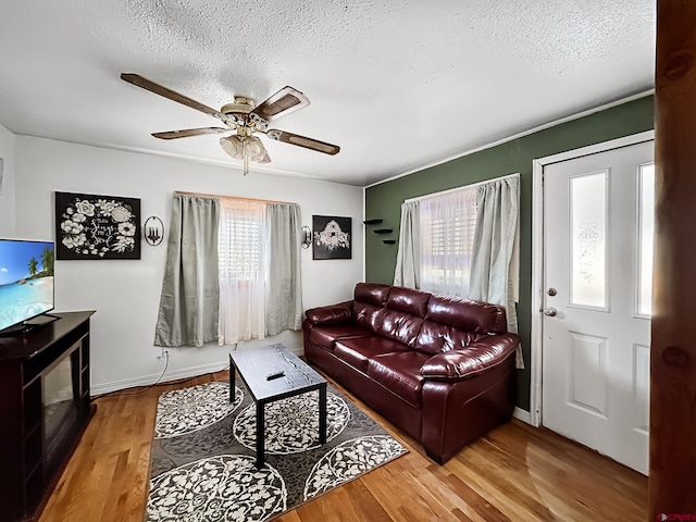 living room with ceiling fan, wood-type flooring, and a textured ceiling