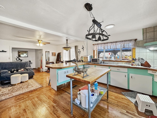 kitchen featuring pendant lighting, ceiling fan, a healthy amount of sunlight, and light wood-type flooring