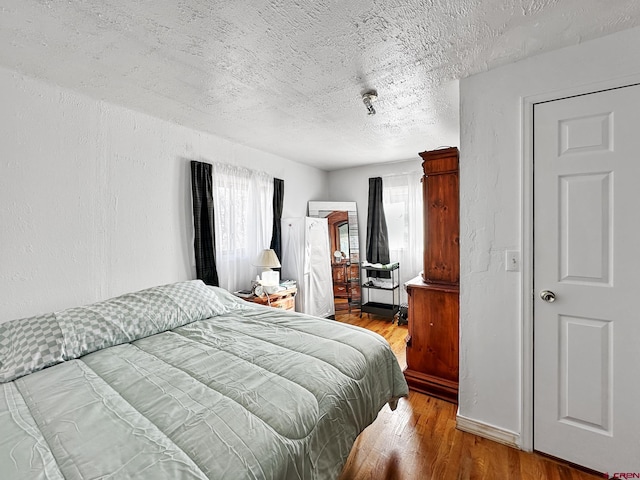 bedroom featuring wood-type flooring and a textured ceiling