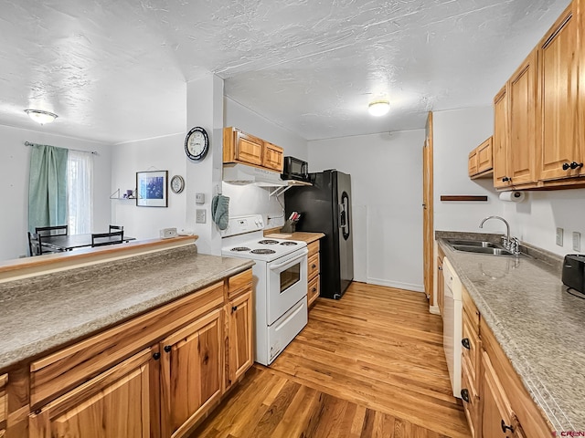 kitchen with a textured ceiling, sink, white appliances, and light hardwood / wood-style flooring