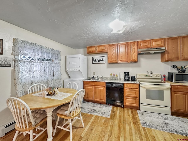 kitchen featuring a baseboard heating unit, light hardwood / wood-style flooring, stacked washing maching and dryer, black dishwasher, and white range with electric stovetop