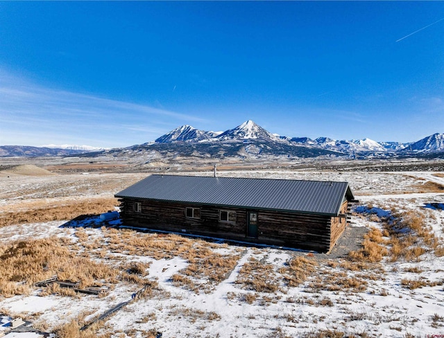 exterior space featuring a mountain view, metal roof, and log exterior