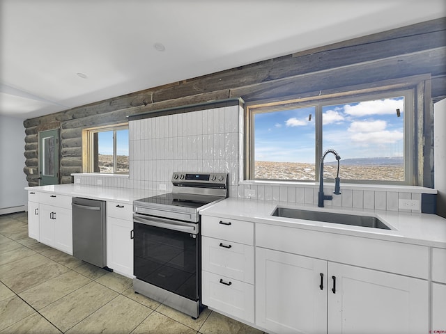 kitchen with light countertops, appliances with stainless steel finishes, a sink, and log walls