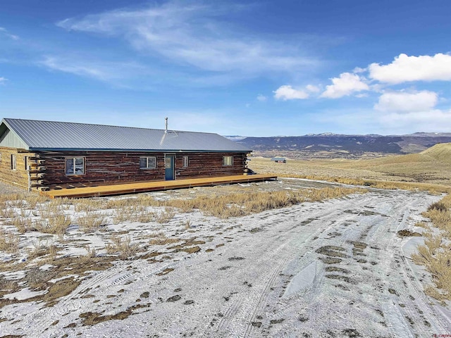 exterior space featuring metal roof, a mountain view, and log siding