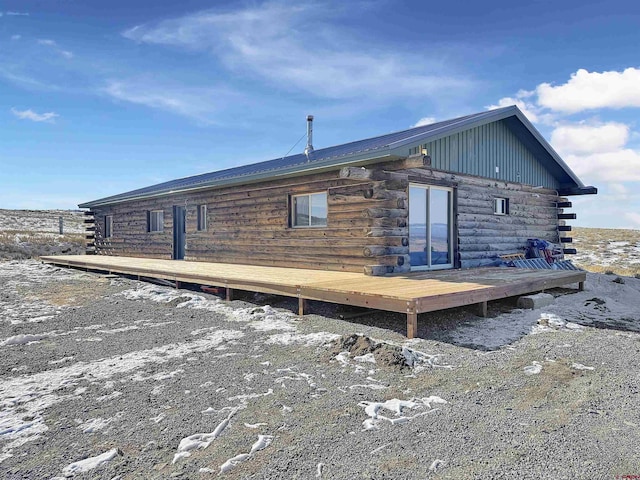 back of house with log siding and a wooden deck