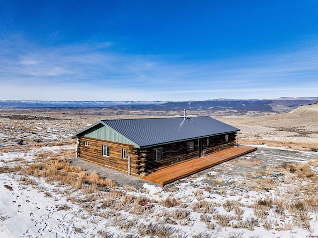 exterior space featuring metal roof, log exterior, and a mountain view