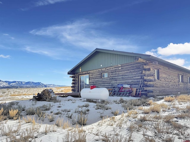 view of snow covered exterior with log exterior and a mountain view