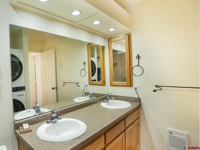 bathroom featuring vanity, heating unit, and stacked washer and clothes dryer