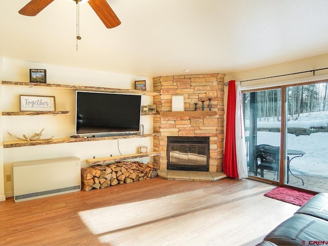 living room with hardwood / wood-style flooring, ceiling fan, and a fireplace