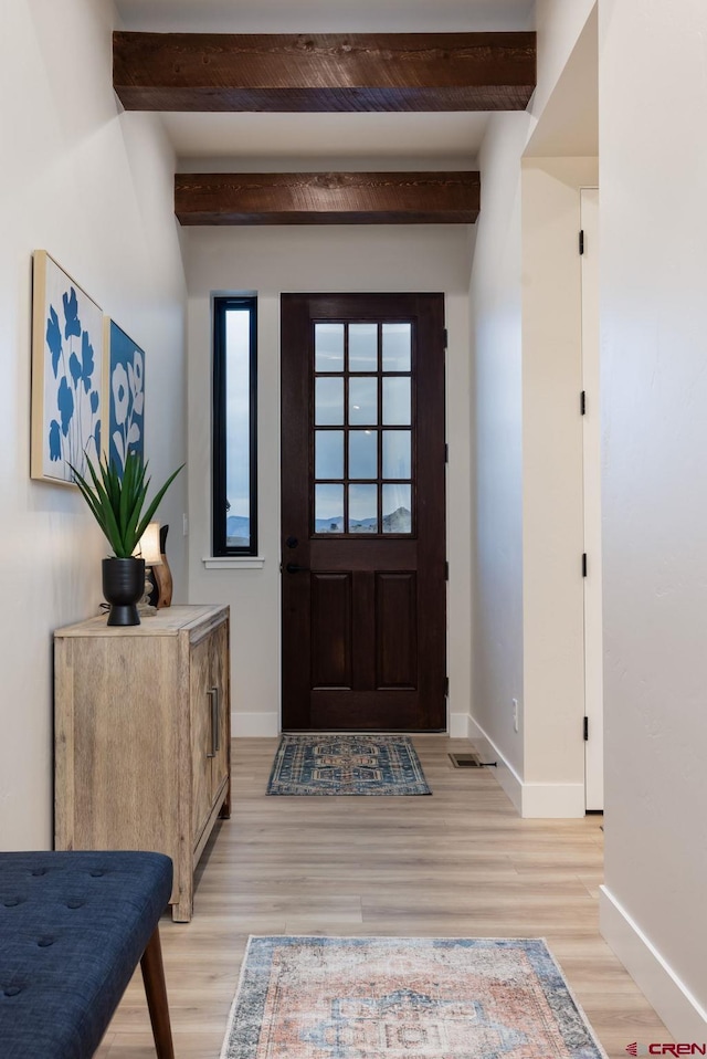 entrance foyer featuring beam ceiling and light hardwood / wood-style flooring