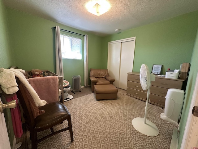 living area featuring light carpet, radiator heating unit, and a textured ceiling