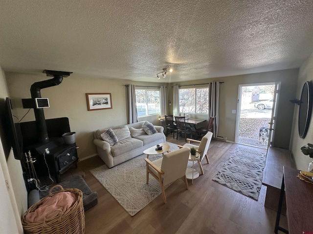 living room featuring a textured ceiling, hardwood / wood-style flooring, and a wood stove