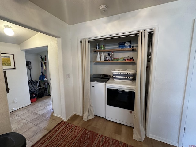 laundry area with light hardwood / wood-style floors and washer and clothes dryer