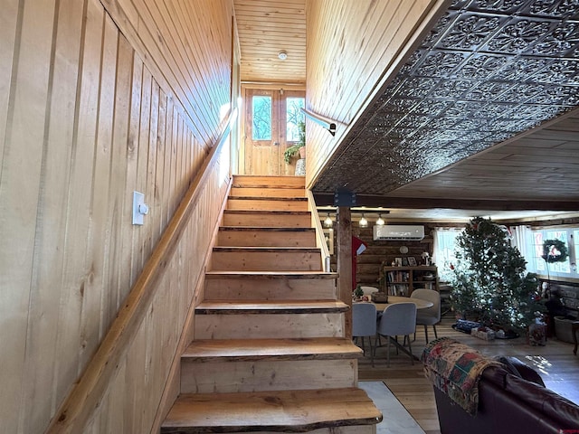 stairway featuring hardwood / wood-style flooring, wood walls, and wood ceiling