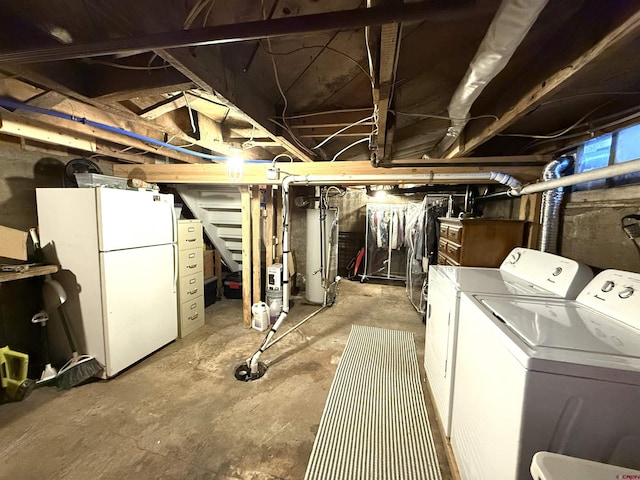 basement with white refrigerator, gas water heater, and independent washer and dryer