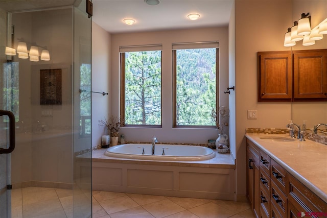 bathroom featuring tile patterned flooring, vanity, and shower with separate bathtub