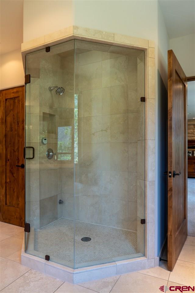 bathroom with tile patterned flooring and walk in shower