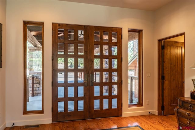 entryway with light wood-type flooring and french doors