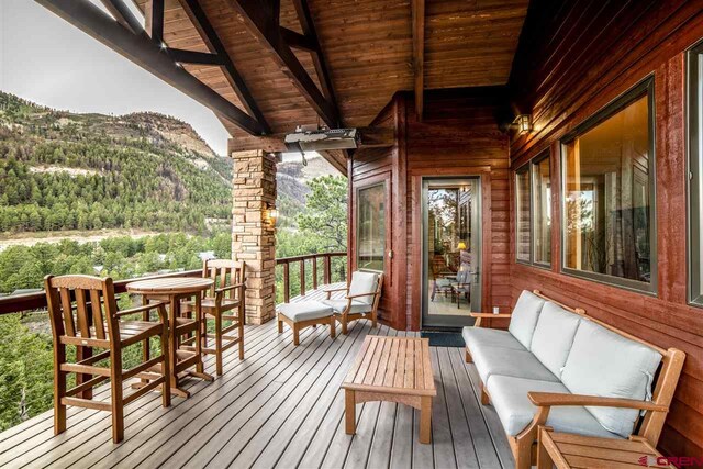 wooden terrace with outdoor lounge area and a mountain view