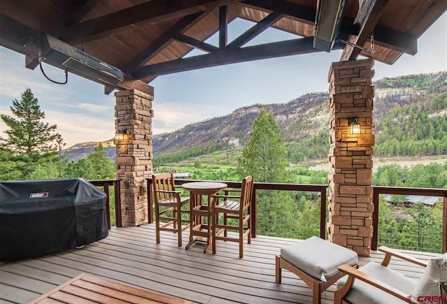 wooden deck featuring a mountain view and a grill