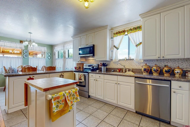 kitchen featuring plenty of natural light, a center island, stainless steel appliances, and sink