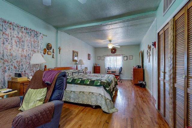 bedroom with ceiling fan, a textured ceiling, and hardwood / wood-style flooring