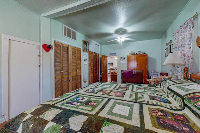 bedroom with ceiling fan and multiple closets