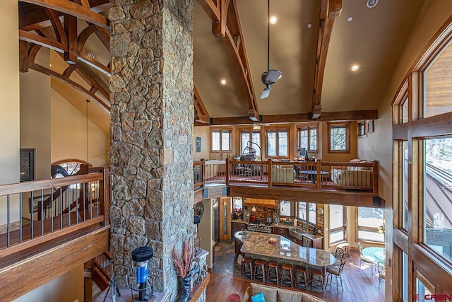 living room featuring beamed ceiling, hardwood / wood-style flooring, and high vaulted ceiling