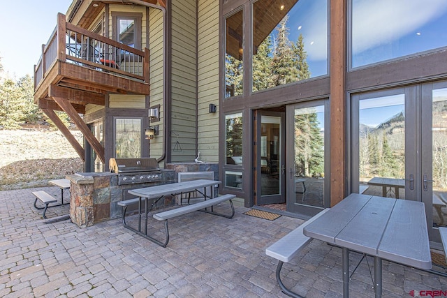 view of patio featuring a grill and a balcony