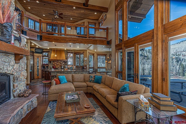 living room featuring ceiling fan, dark wood-type flooring, and a high ceiling