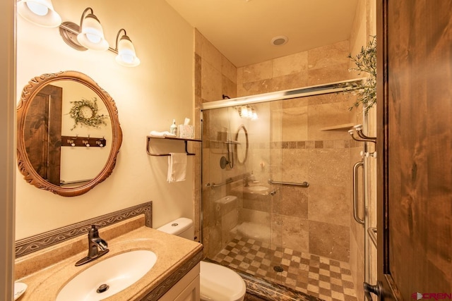 bathroom featuring toilet, vanity, and walk in shower