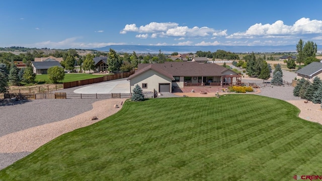 rear view of property featuring a mountain view and a lawn