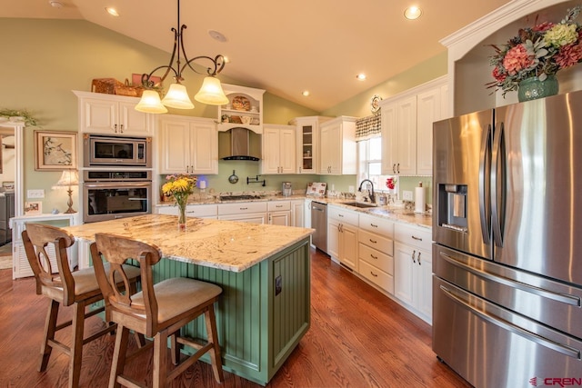 kitchen with a center island, stainless steel appliances, light stone counters, pendant lighting, and vaulted ceiling