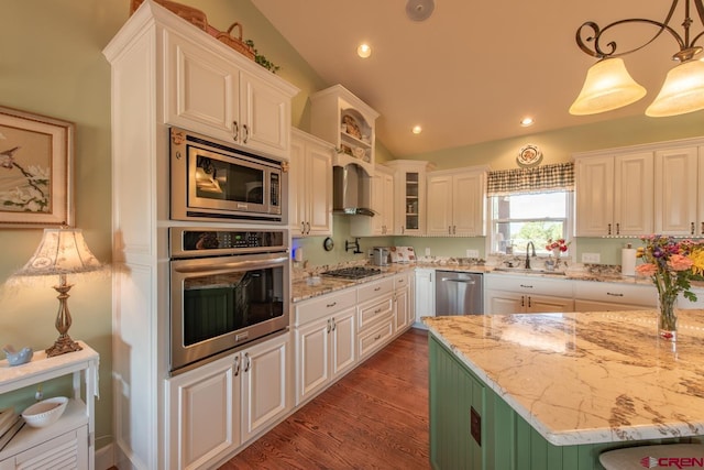 kitchen with white cabinets, sink, decorative light fixtures, light stone counters, and stainless steel appliances