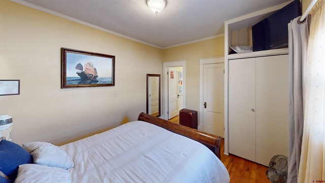 bedroom with wood-type flooring and ornamental molding