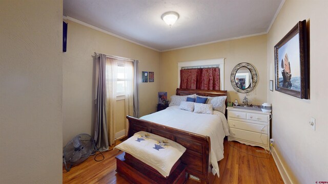 bedroom with hardwood / wood-style flooring and ornamental molding